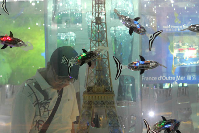 Three rectangular aquariums inside the France Pavilion held miniature monuments, including the Arc de Triumph and the Eiffel Tower. The icons were submerged in water and surround by dozens of robotic fish flashing like disco balls.