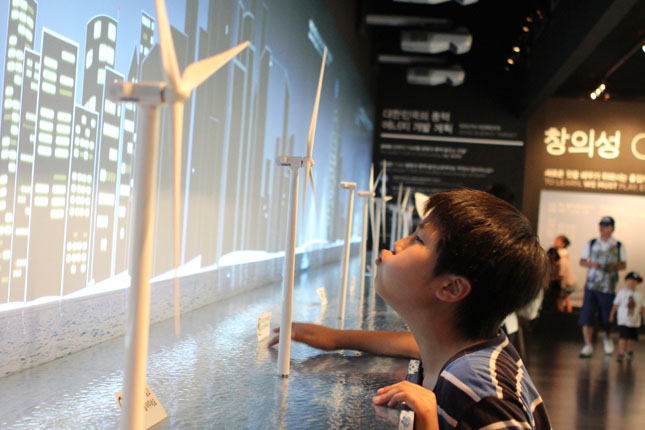 A series of miniature wind turbines along one wall of the Denmark Pavilion allows attendees to see how simple it is to make Green energy. Plant your feet in steps painted on the floor, then blow gently on the windmill-like structures, and they begin to spin like Dervishes.