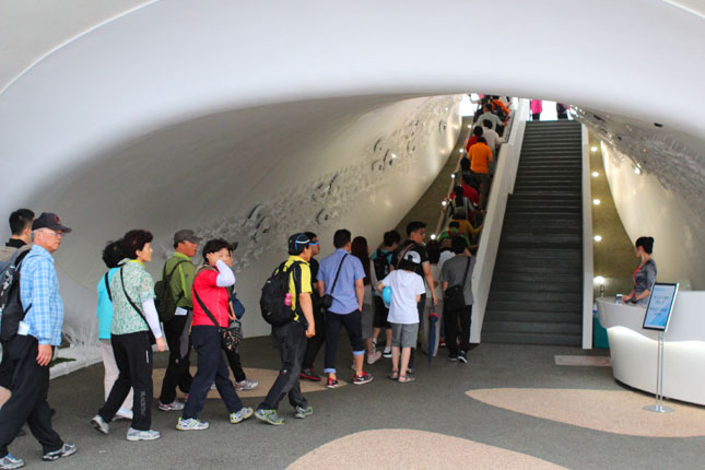 The open-air platform in the Posco Pavilion blew wind down an escalator, activating the spin cycle on tiny windmill-like devices attached to a wall.