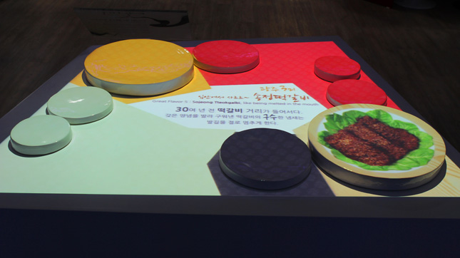In the Gwanju Pavilion, foodies could watch visuals of regional cuisine projection-mapped onto a table setting for eight as if the perfectly placed courses of duck stew and kimchee appeared on the plates out of thin air.